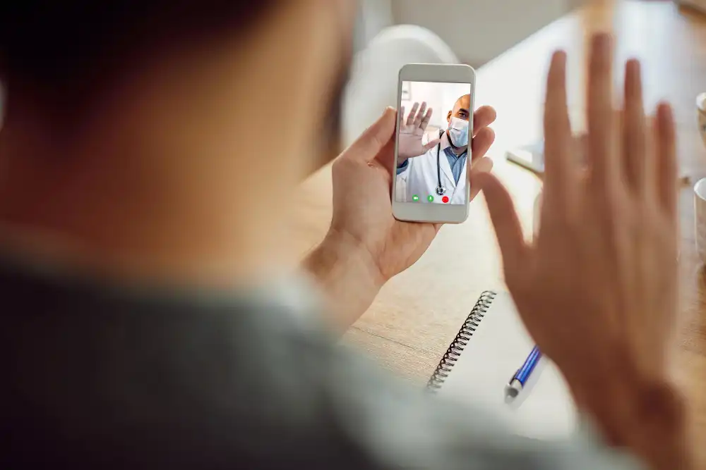 closeup african american doctor greeting his patient during video call mobile phone